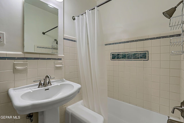 818 Kerbey Ave, El Paso, TX 79902 - bathroom with tile walls, shower / bath combo with shower curtain, a sink, and wainscoting