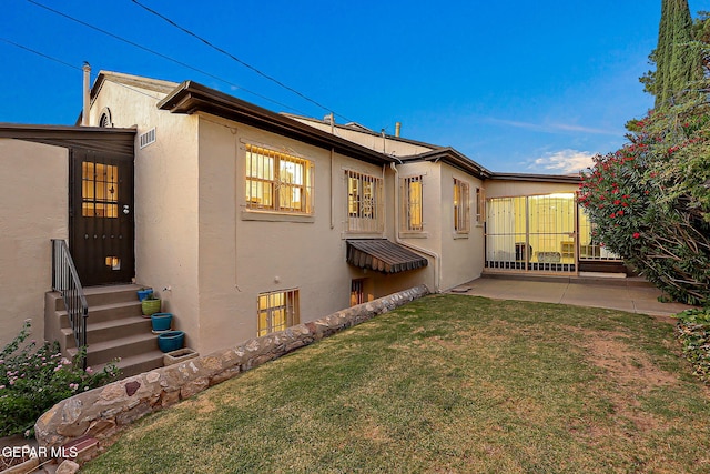 818 Kerbey Ave, El Paso, TX 79902 - back of house featuring stucco siding, entry steps, a yard, and a patio area