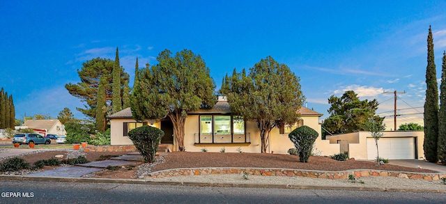 818 Kerbey Ave, El Paso, TX 79902 - view of front of home featuring stucco siding, driveway, a porch, and a garage