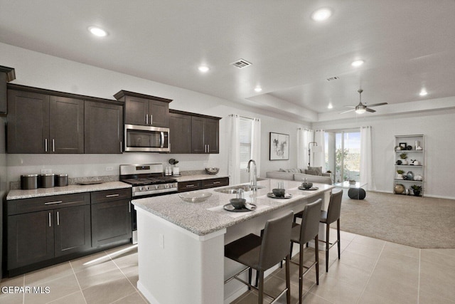 916 Pettus Pl, El Paso, TX 79928 - kitchen with stainless steel appliances, open floor plan, light carpet, ceiling fan, and a kitchen island with sink