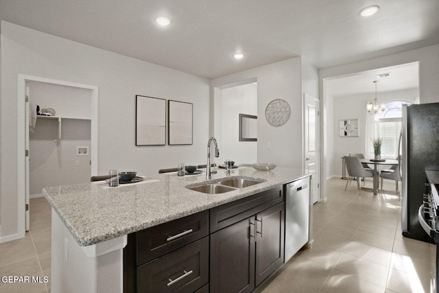 916 Pettus Pl, El Paso, TX 79928 - kitchen featuring a sink, stainless steel appliances, light tile patterned floors, a kitchen island with sink, and light stone countertops