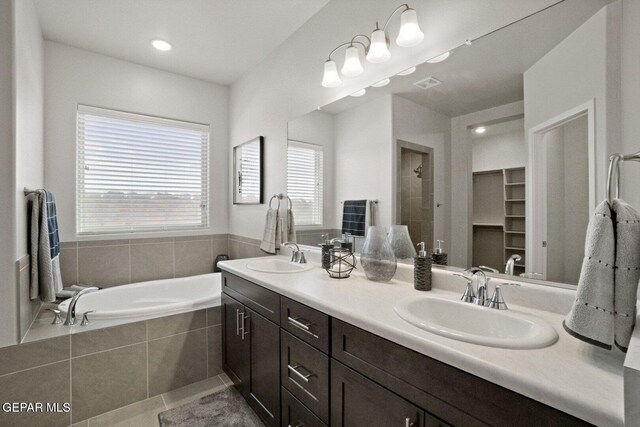 916 Pettus Pl, El Paso, TX 79928 - bathroom with double vanity, a garden tub, a walk in closet, a tile shower, and tile patterned floors