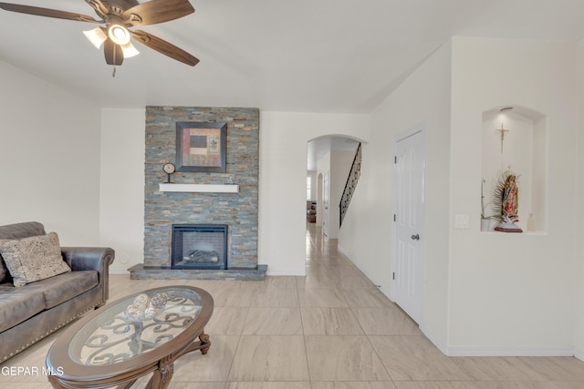2201 Morning Mist Pl, El Paso, TX 79938 - living room featuring arched walkways, ceiling fan, a fireplace, and baseboards