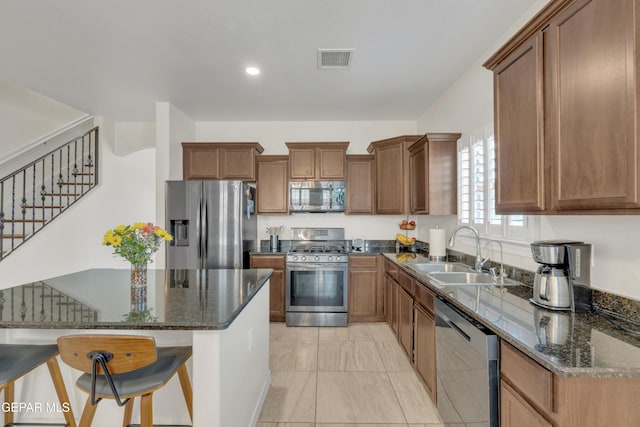 2201 Morning Mist Pl, El Paso, TX 79938 - kitchen featuring appliances with stainless steel finishes, a sink, dark stone countertops, brown cabinetry, and recessed lighting
