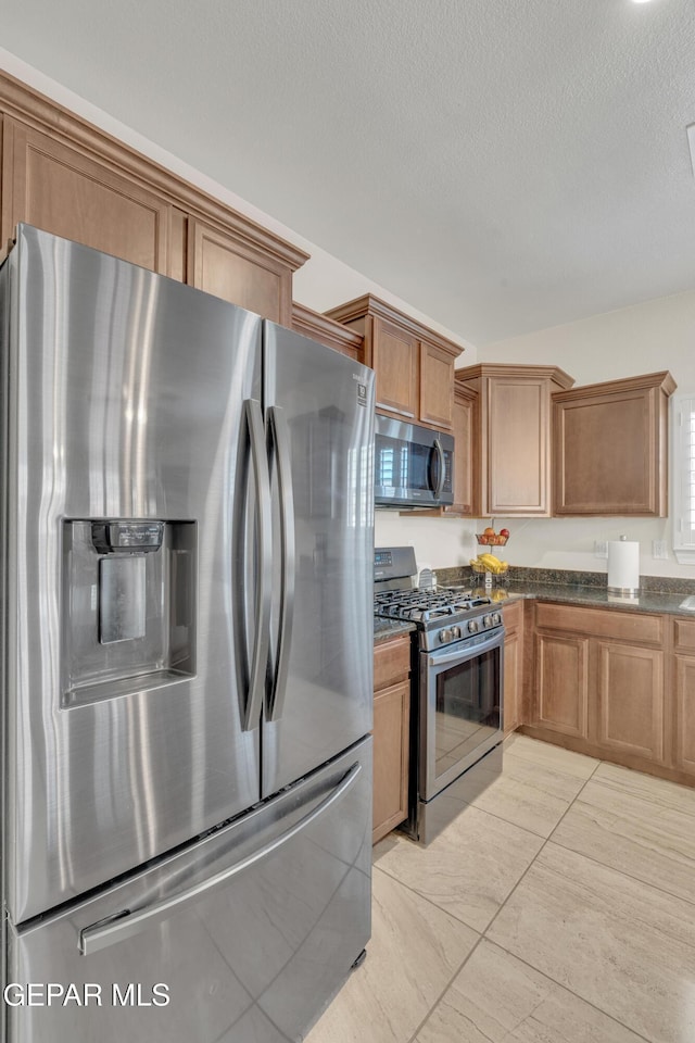 2201 Morning Mist Pl, El Paso, TX 79938 - kitchen featuring appliances with stainless steel finishes, brown cabinets, and a textured ceiling
