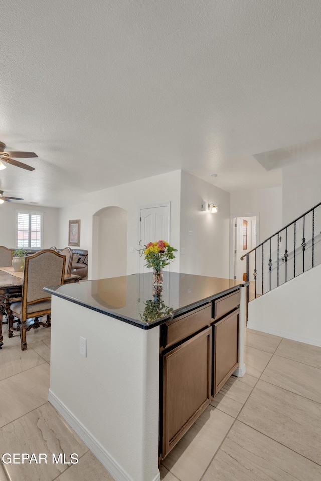 2201 Morning Mist Pl, El Paso, TX 79938 - kitchen with a ceiling fan, a center island, a textured ceiling, light tile patterned floors, and arched walkways