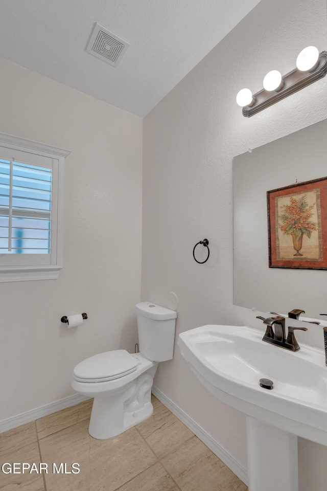 2201 Morning Mist Pl, El Paso, TX 79938 - half bath with toilet, a sink, baseboards, and tile patterned flooring