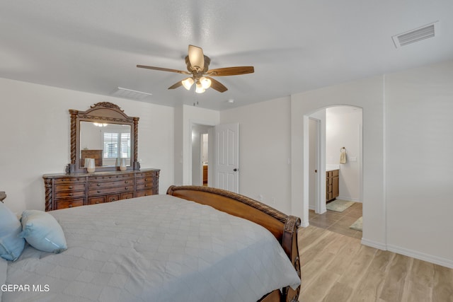 2201 Morning Mist Pl, El Paso, TX 79938 - bedroom with arched walkways, light wood finished floors, a ceiling fan, connected bathroom, and baseboards