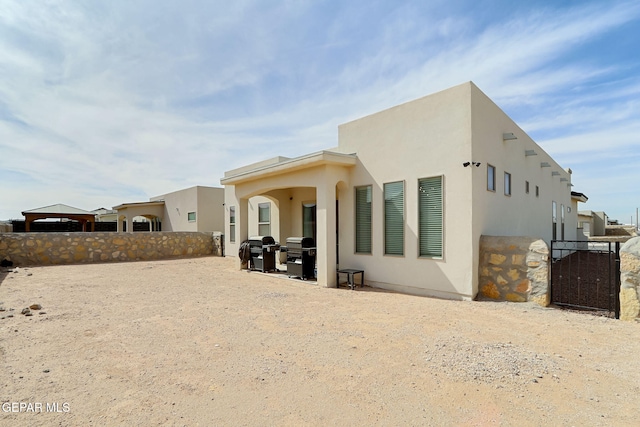 974 Airship Pl, Horizon City, TX 79928 - rear view of property with stucco siding and a gate