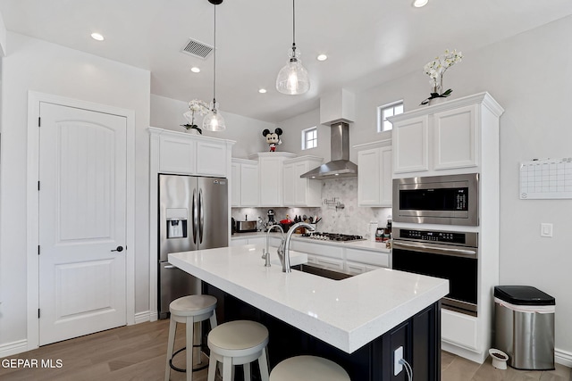 974 Airship Pl, Horizon City, TX 79928 - kitchen with appliances with stainless steel finishes, wall chimney exhaust hood, a sink, decorative backsplash, and white cabinets