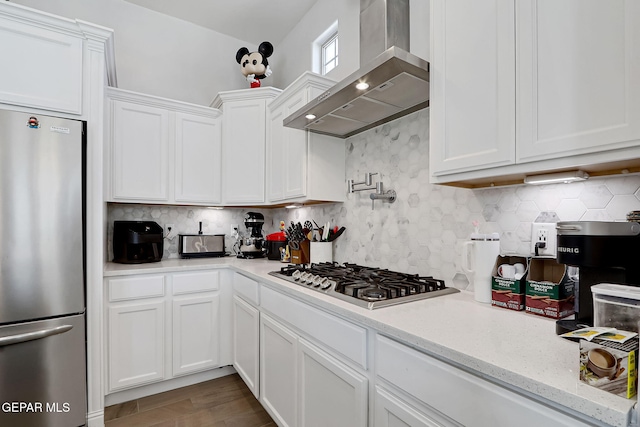 974 Airship Pl, Horizon City, TX 79928 - kitchen with stainless steel appliances, wall chimney range hood, white cabinets, backsplash, and light stone counters