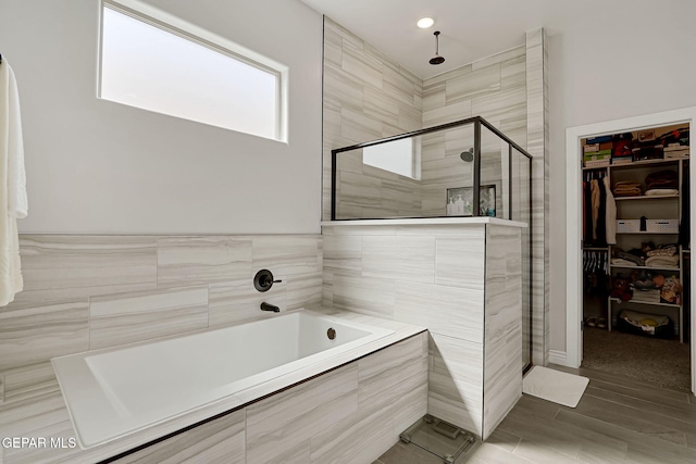 974 Airship Pl, Horizon City, TX 79928 - bathroom featuring a stall shower, a bath, and a spacious closet