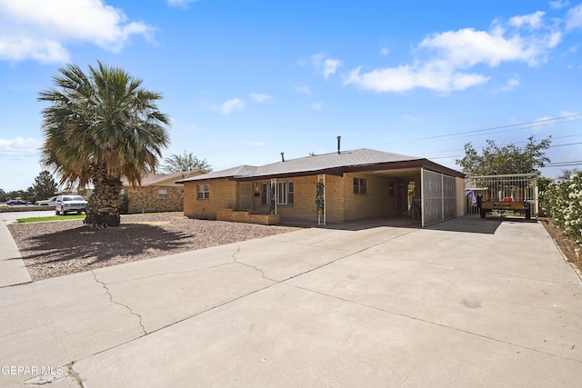 8108 Edgemere Blvd, El Paso, TX 79925 - view of front facade with driveway, brick siding, and a carport