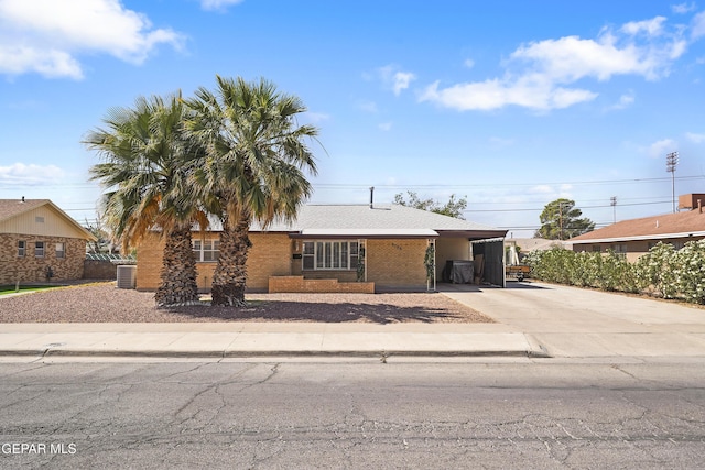 8108 Edgemere Blvd, El Paso, TX 79925 - view of front facade with driveway, brick siding, central air condition unit, and a carport