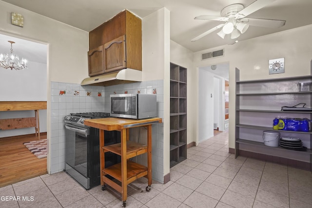 8108 Edgemere Blvd, El Paso, TX 79925 - kitchen featuring appliances with stainless steel finishes, under cabinet range hood, light tile patterned floors, ceiling fan, and a chandelier