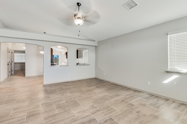 14294 Kayla Mia Dr, El Paso, TX 79938 - unfurnished living room with a ceiling fan, vaulted ceiling, baseboards, light wood-style flooring, and arched walkways