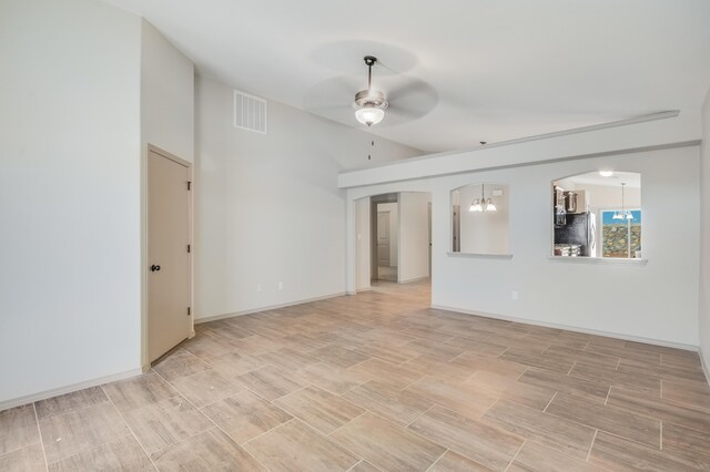 14294 Kayla Mia Dr, El Paso, TX 79938 - empty room featuring ceiling fan, lofted ceiling, arched walkways, wood finish floors, and baseboards