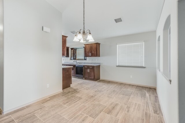 14294 Kayla Mia Dr, El Paso, TX 79938 - kitchen with black dishwasher, a chandelier, light wood-style flooring, pendant lighting, and baseboards