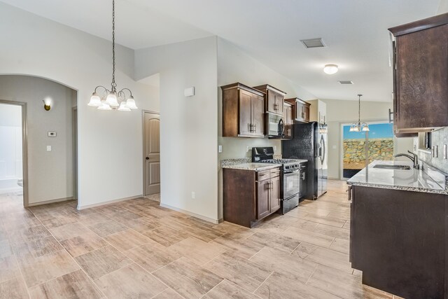 14294 Kayla Mia Dr, El Paso, TX 79938 - kitchen featuring gas range, black microwave, a sink, dark brown cabinetry, and light stone countertops
