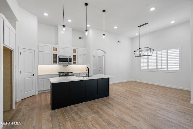 13797 Summer Wave Ave, El Paso, TX 79928 - kitchen with stainless steel appliances, a sink, white cabinetry, light countertops, and tasteful backsplash