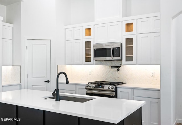 13797 Summer Wave Ave, El Paso, TX 79928 - kitchen with appliances with stainless steel finishes, a sink, light countertops, and decorative backsplash