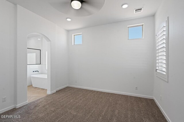 13797 Summer Wave Ave, El Paso, TX 79928 - unfurnished bedroom featuring carpet flooring, arched walkways, baseboards, ensuite bathroom, and a ceiling fan
