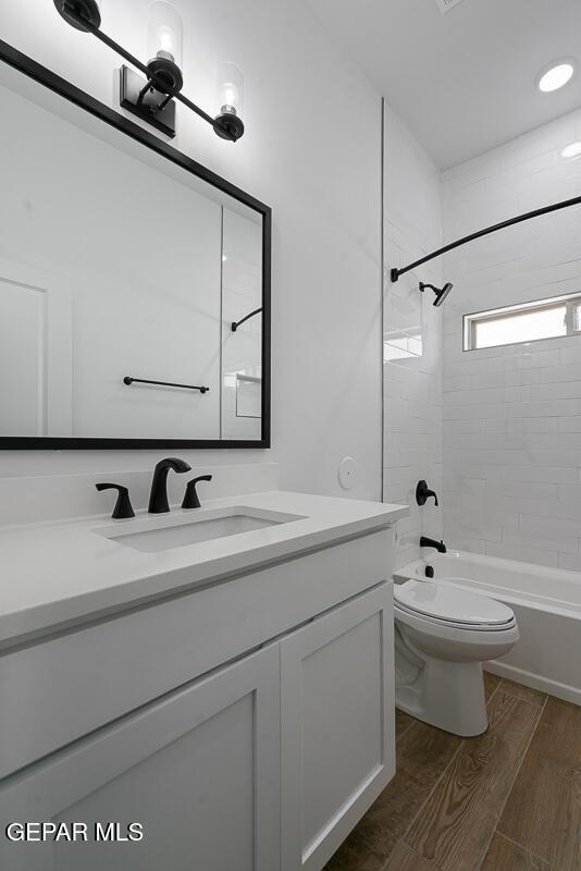 13797 Summer Wave Ave, El Paso, TX 79928 - bathroom with vanity, toilet, wood finished floors, and bathing tub / shower combination