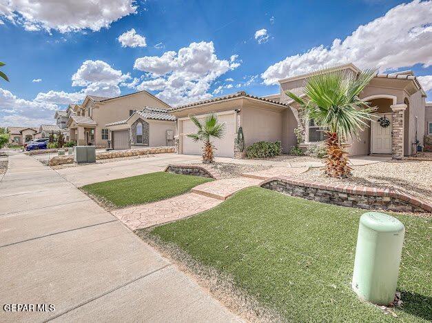 13649 Mill Hill Ct, El Paso, TX 79928 - mediterranean / spanish house with stucco siding, concrete driveway, a front yard, an attached garage, and a tile roof