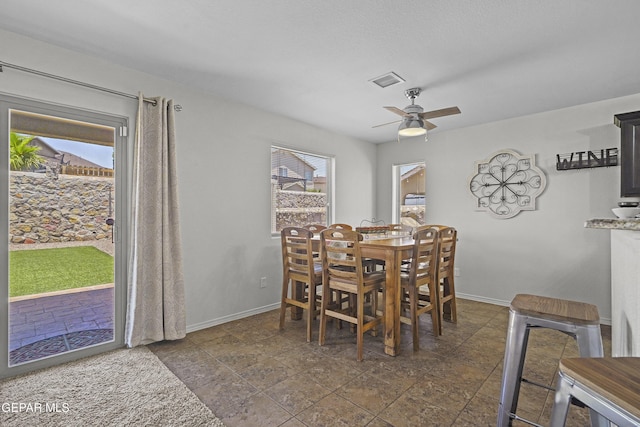 7237 Dust Storm Ln, El Paso, TX 79934 - dining area featuring plenty of natural light, a ceiling fan, baseboards, and dark stone finish flooring