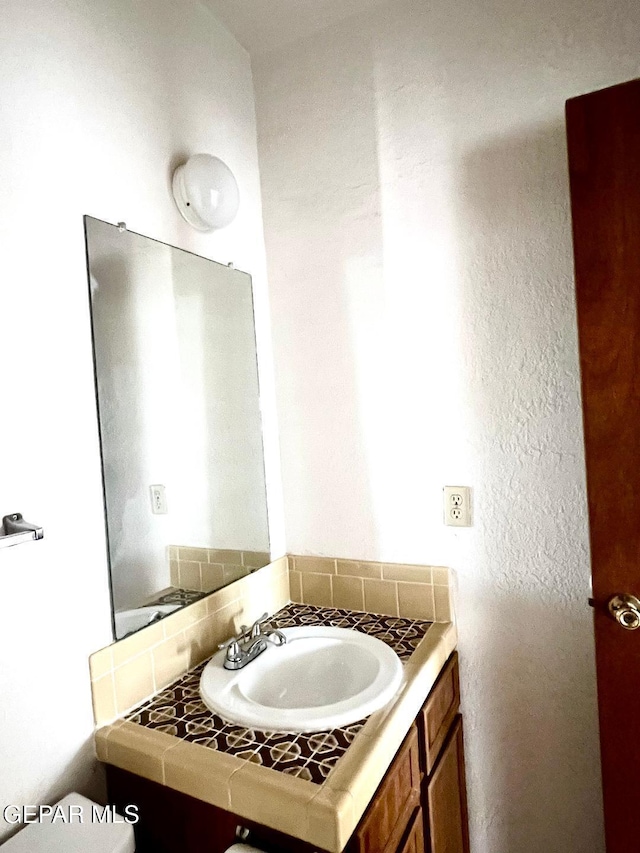2520 San Jose Ave Unit 2D, El Paso, TX 79930 - half bath with vanity, a textured wall, and toilet