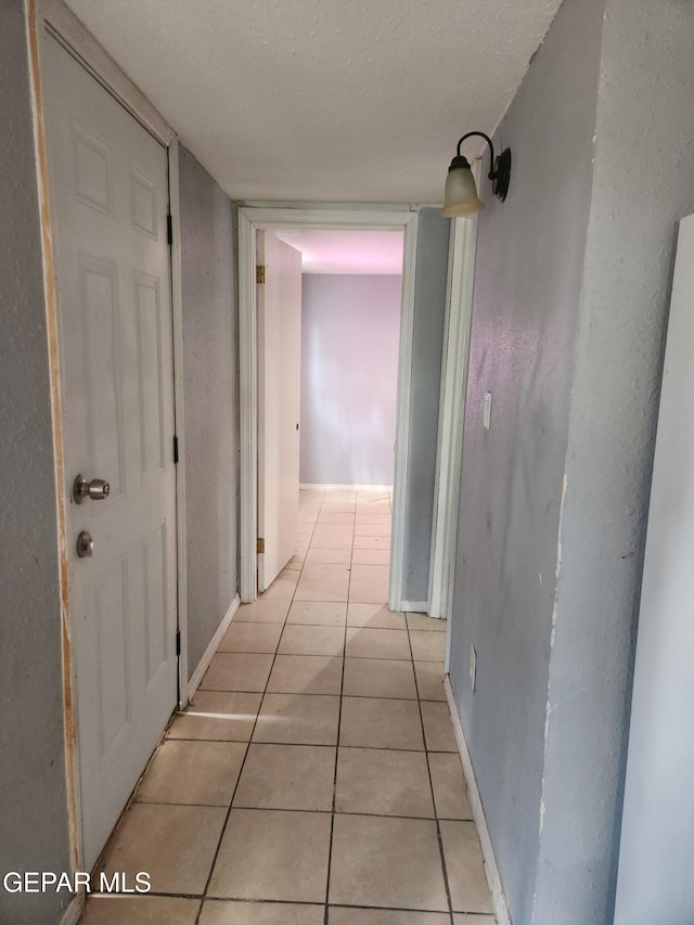 7511 Howard St, El Paso, TX 79904 - hallway featuring light tile patterned floors, baseboards, and a textured ceiling