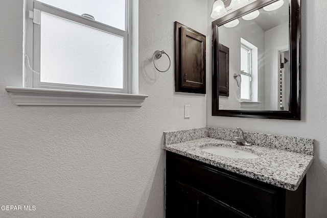 14701 Tim Hardaway, El Paso, TX 79938 - bathroom featuring healthy amount of natural light, vanity, and a textured wall