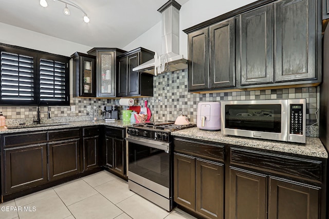 14701 Tim Hardaway, El Paso, TX 79938 - kitchen featuring appliances with stainless steel finishes, a sink, wall chimney exhaust hood, light tile patterned floors, and tasteful backsplash