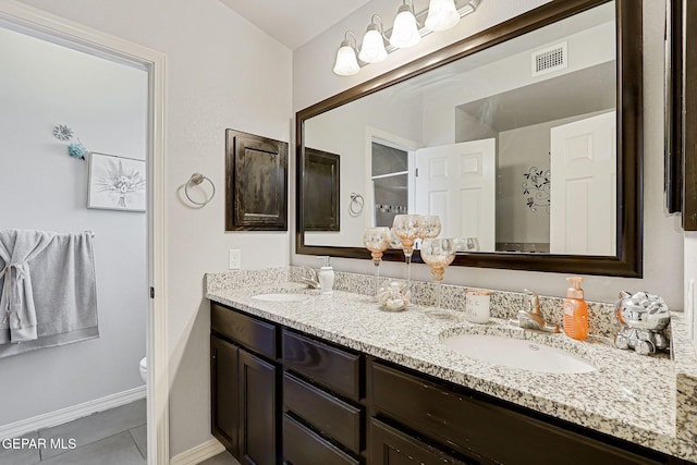 14701 Tim Hardaway, El Paso, TX 79938 - full bathroom featuring double vanity, toilet, tile patterned floors, and baseboards