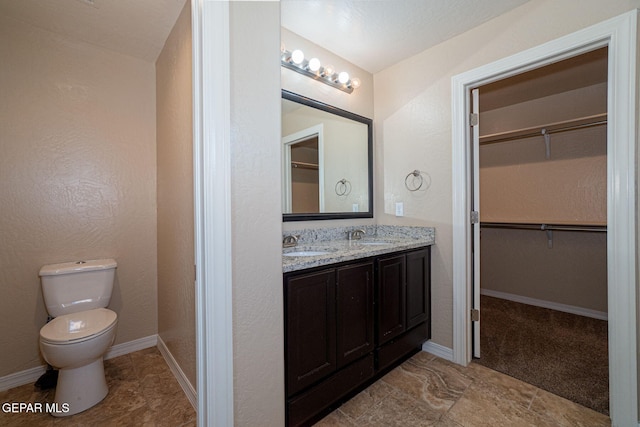 117 Camino Cresta Pl, Horizon City, TX 79928 - full bathroom with toilet, double vanity, a spacious closet, and baseboards