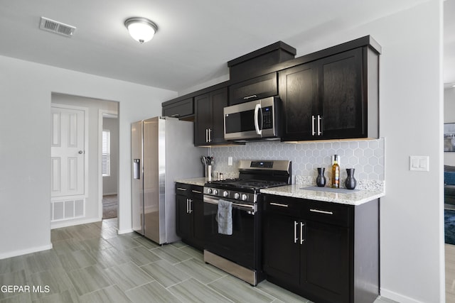 13142 Emerald Isle St, El Paso, TX 79928 - kitchen featuring stainless steel appliances, tasteful backsplash, and light stone counters