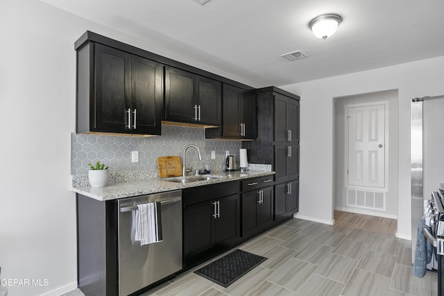13142 Emerald Isle St, El Paso, TX 79928 - kitchen featuring dishwasher, backsplash, light stone countertops, and light wood-style flooring