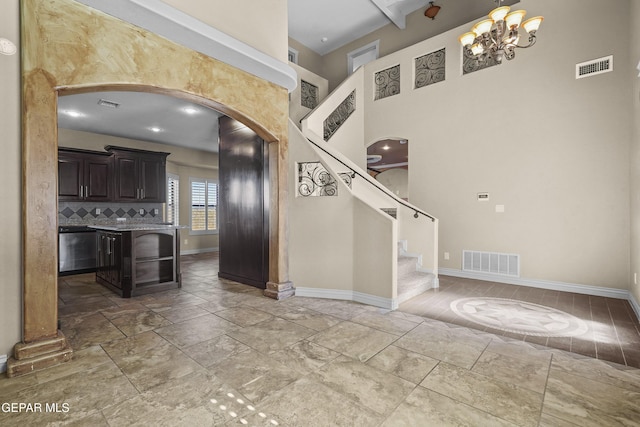 2909 Pino Triste Dr, El Paso, TX 79938 - kitchen featuring arched walkways, a chandelier, light countertops, a high ceiling, and stone tile flooring
