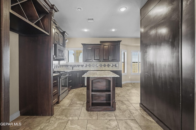 2909 Pino Triste Dr, El Paso, TX 79938 - kitchen featuring stainless steel appliances, open shelves, backsplash, dark brown cabinetry, and a kitchen island
