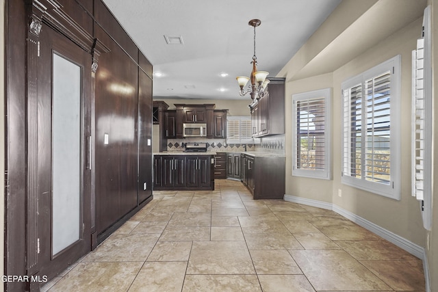2909 Pino Triste Dr, El Paso, TX 79938 - kitchen with stainless steel microwave, a chandelier, light countertops, dark brown cabinets, and recessed lighting
