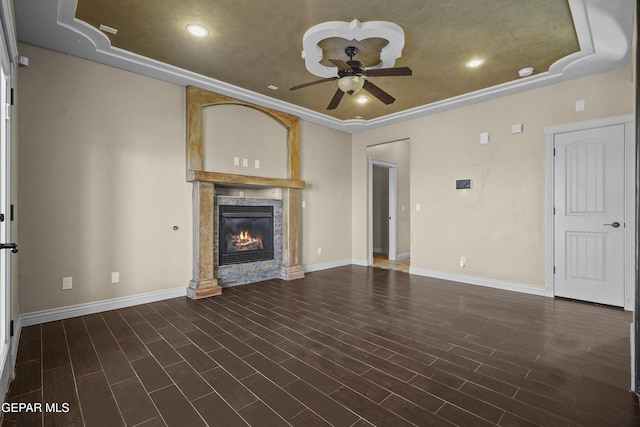 2909 Pino Triste Dr, El Paso, TX 79938 - unfurnished living room featuring a ceiling fan, a raised ceiling, a glass covered fireplace, dark wood-style flooring, and ornamental molding