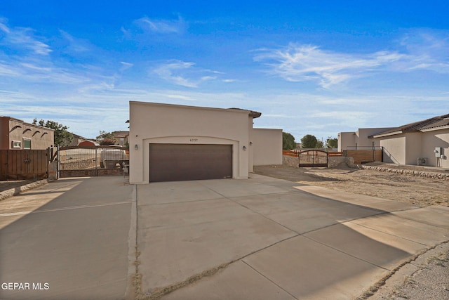 6037 Vicente Gomez Ln, El Paso, TX 79932 - view of side of property featuring a gate, an attached garage, stucco siding, and driveway