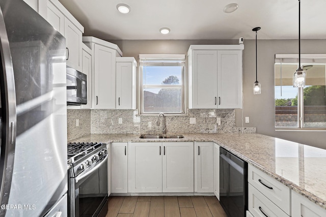6037 Vicente Gomez Ln, El Paso, TX 79932 - kitchen with stainless steel appliances, a sink, backsplash, and white cabinetry