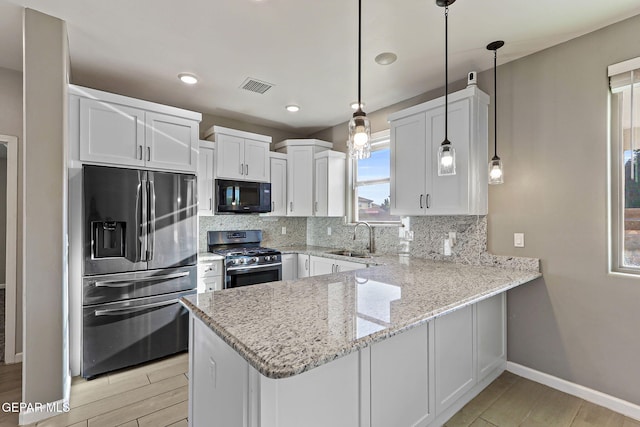 6037 Vicente Gomez Ln, El Paso, TX 79932 - kitchen featuring stainless steel appliances, a sink, a peninsula, white cabinets, and decorative backsplash