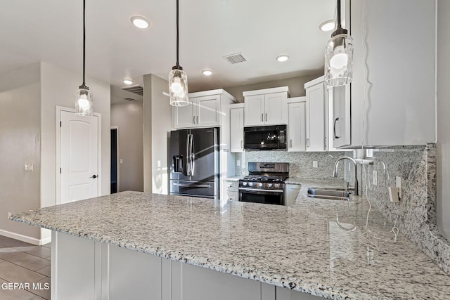 6037 Vicente Gomez Ln, El Paso, TX 79932 - kitchen featuring fridge with ice dispenser, black microwave, stainless steel gas range oven, a sink, and light stone counters
