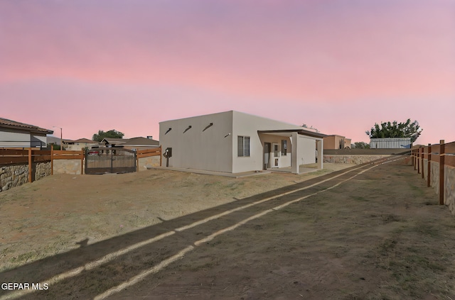 6037 Vicente Gomez Ln, El Paso, TX 79932 - back of house at dusk with a fenced backyard and stucco siding