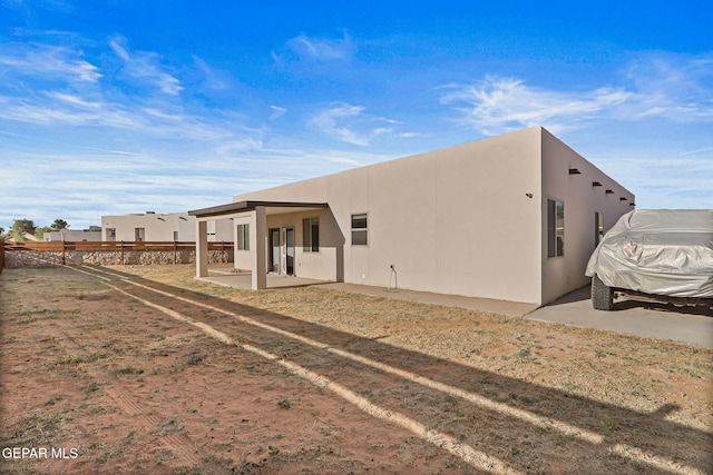 6037 Vicente Gomez Ln, El Paso, TX 79932 - rear view of property featuring stucco siding and a patio area