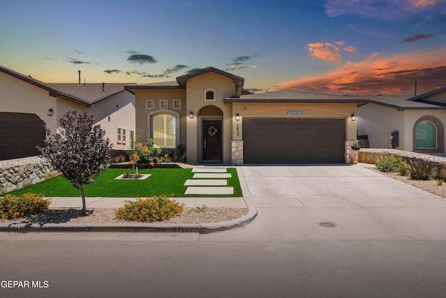 3452 David Palacio Dr, El Paso, TX 79938 - mediterranean / spanish-style home with a garage, stucco siding, driveway, a front yard, and stone siding