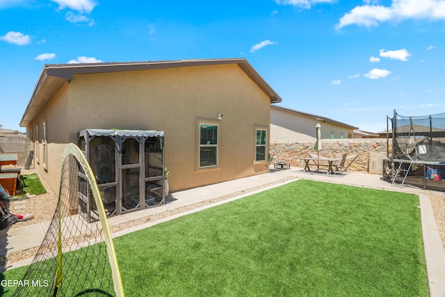 3452 David Palacio Dr, El Paso, TX 79938 - rear view of house with a trampoline, stucco siding, a patio, and a fenced backyard