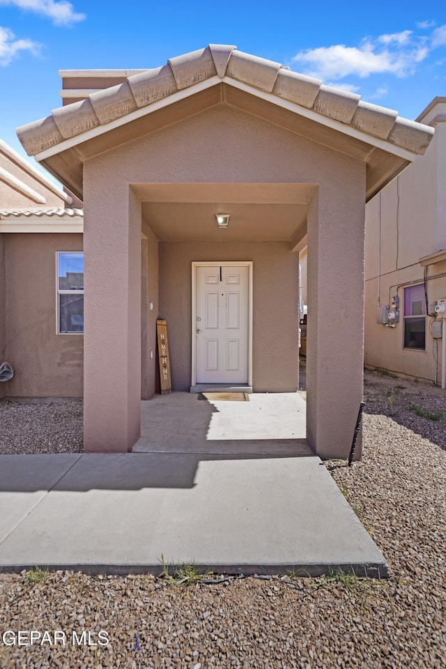 14236 Rattler Point Dr, El Paso, TX 79938 - doorway to property featuring stucco siding and a tiled roof